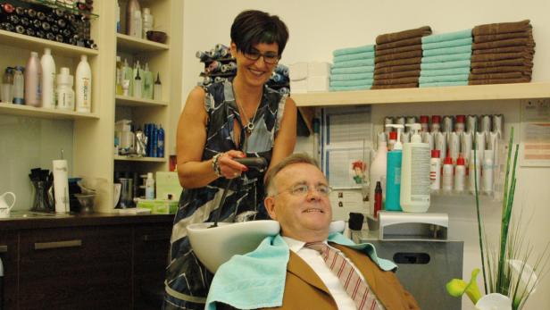 Ein Mann bekommt in einem Friseursalon eine Haarwäsche.