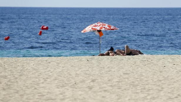 People sunbathe at Magaluf beach in Mallorca