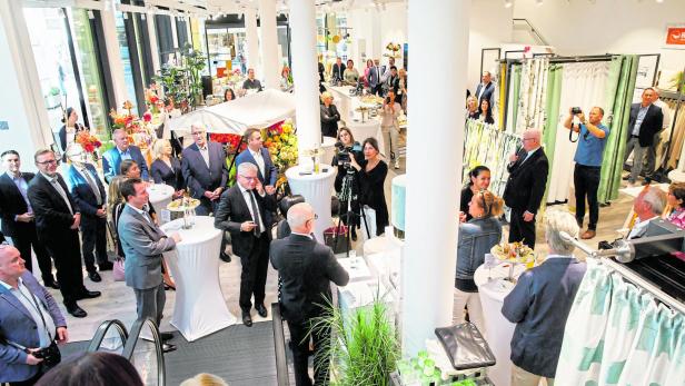 Peter Hildebrand (rechts) spricht bei der Eröffnung zu den Gästen