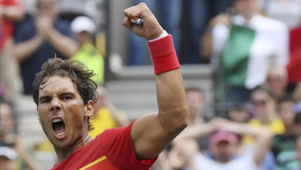 Rafael Nadal jubelt mit geballter Faust und rotem Schweißband auf dem Tennisplatz.