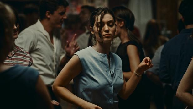 Eine junge Frau tanzt mit geschlossenen Augen in einer Menschenmenge.