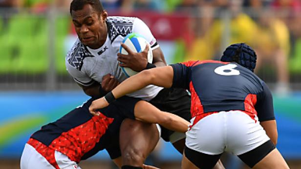 Ein Rugbyspieler wird von zwei Gegenspielern attackiert.