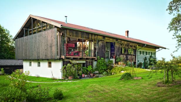 Ein umgebautes Bauernhaus mit Holzelementen und einem gepflegten Garten.
