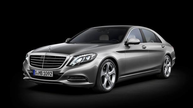 Eine silberne Mercedes-Benz S-Klasse vor einem schwarzen Hintergrund.