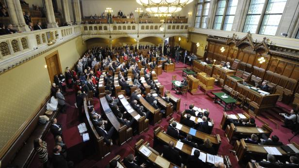 Eine Sitzung in einem großen Saal mit vielen Menschen in Anzügen.