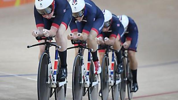 Das britische Bahnradsportteam fährt in einer Reihe auf einer Radrennbahn.