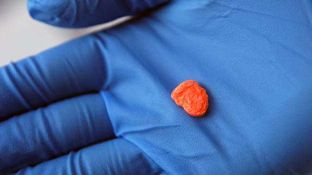 A police officer shows a ecstasy pill stamped with the face of U.S. President Donald Trump after a seizure by Chilean authorities in Concepcion