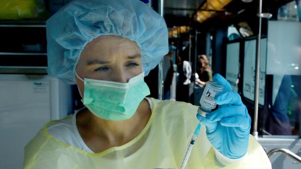 A health worker draws COVID-19 vaccine into a syringe inside the COVID-19 Impftram vaccination tram in Zurich