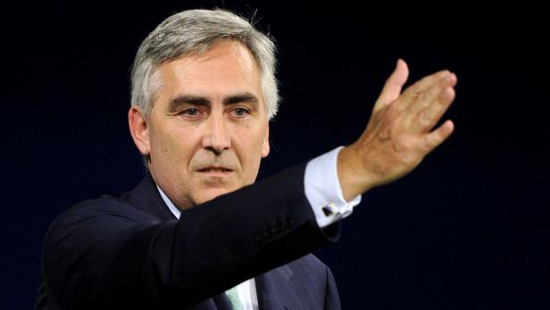 Ein Mann im Anzug gestikuliert mit der Hand.