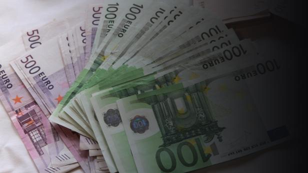 Ein Stapel von 100- und 500-Euro-Scheinen liegt auf einem Tisch.