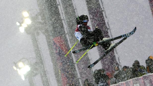 Ein Skifahrer springt während eines Schneesturms in der Luft.