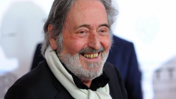 Porträt von Jean-Paul Belmondo mit Schal und Jackett.