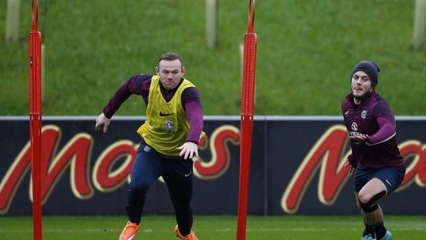 England's Rooney races Wilshere during a training
