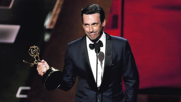 Jon Hamm hält bei einer Preisverleihung einen Emmy in der Hand.