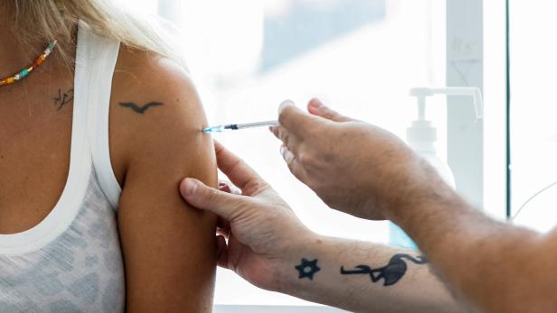 FILE PHOTO: An Israeli woman receives a third shot of coronavirus disease (COVID-19) vaccine in Tel Aviv