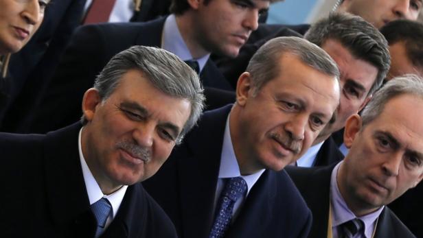 Mehrere Männer in Anzügen, darunter Recep Tayyip Erdoğan, bei einer Veranstaltung.