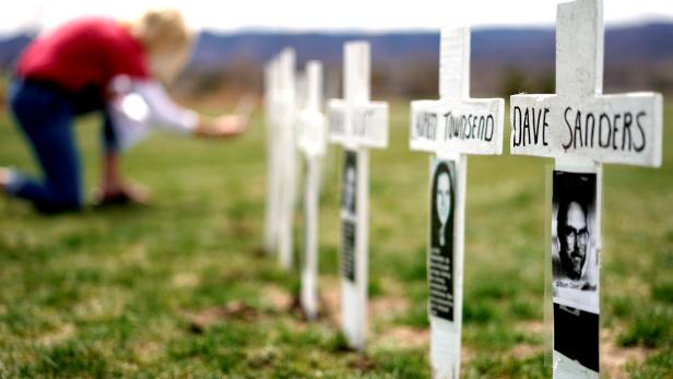 A woman looks at a line of crosses commemorating those killed in the Columbine High School shooting on the 20th anniversary of the attack in Littleton