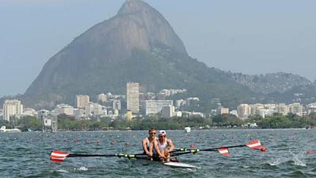 Zwei Ruderer in einem Doppelzweier auf einem See vor der Skyline von Rio de Janeiro.