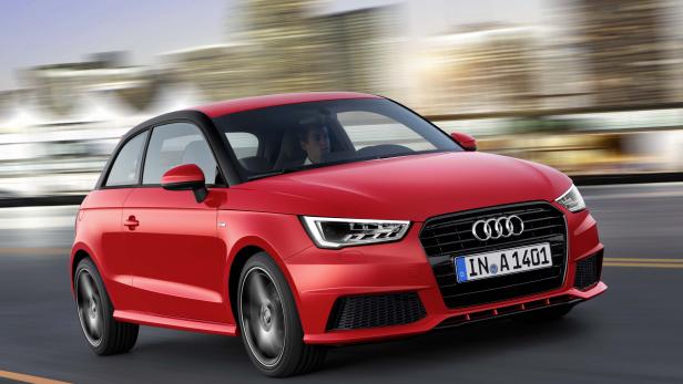 Ein roter Audi A1 fährt auf einer Straße in der Stadt.
