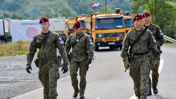 FILE PHOTO: Polish soldiers, part of the peacekeeping mission in Kosovo, KFOR, pass through barricades near the border crossing between Kosovo and Serbia in Jarinje, Kosovo, September 28,