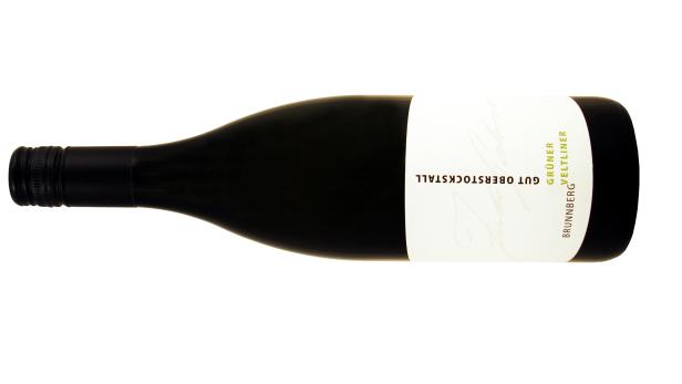 Eine Flasche Grüner Veltliner vom Gut Oberstockstall liegt auf der Seite.