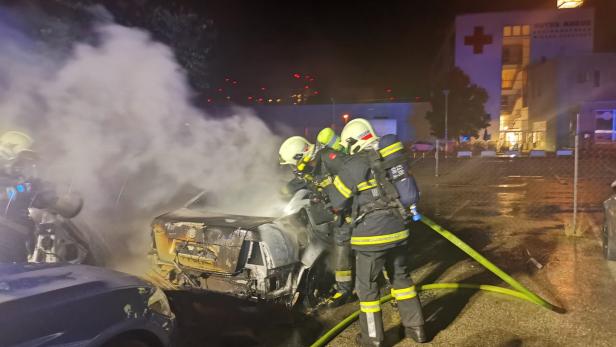 Feuer vernichtete Fahrzeuge am Parkplatz von Autowerkstätte