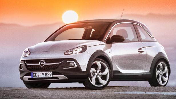 Ein silberner Opel Adam vor einem Sonnenuntergang.