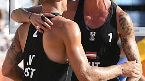 Zwei Beachvolleyballspieler der österreichischen Nationalmannschaft umarmen sich.