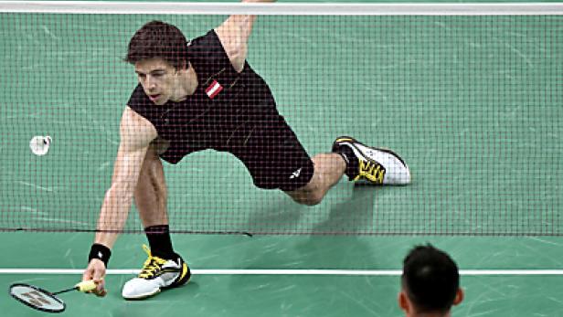 Ein Badmintonspieler schlägt einen Ball über das Netz.