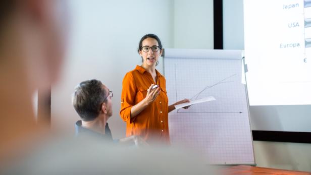 Businesswoman giving presentation to colleagues