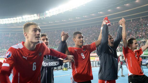 Österreichische Fußballspieler feiern vor einer Zuschauermenge.