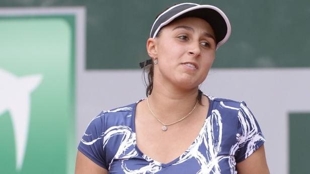 Eine Tennisspielerin mit Visier bei einem Tennismatch.