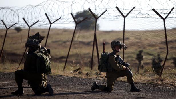 epa03720607 Israeli soldiers are seen moving on a military training ground in the center of Golan Heights, during an Israeli military exercise near the Israeli-Syrian border, 27 May 2013. EPA/ABIR SULTAN