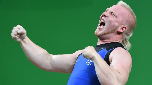 Ein Gewichtheber aus Finnland jubelt mit geballten Fäusten und geöffnetem Mund.