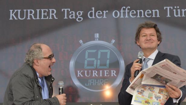 Zwei Männer stehen vor einer Leinwand zum „Kurier Tag der offenen Tür“.