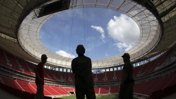 Labourers stand at the National Mane Garrincha stadium in Brasilia May 10, 2013. The stadium will be one of the venues for the 2013 Confederations Cup and the 2014 World Cup. According to the consortium in charge, the construction of the stadium is considered around 97 percent complete. REUTERS/Ueslei Marcelino (BRAZIL - Tags: SPORT SOCCER BUSINESS CONSTRUCTION)