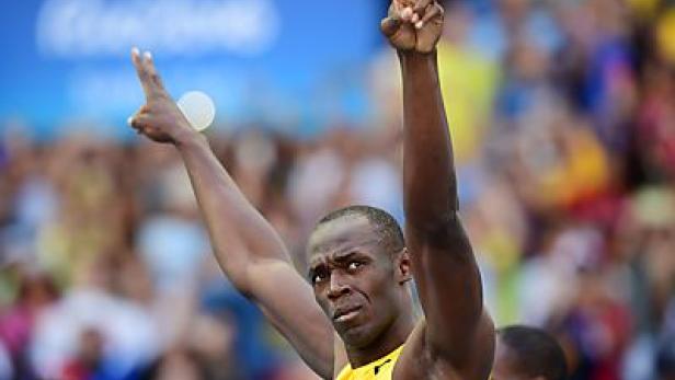 Usain Bolt feiert mit erhobenen Armen einen Sieg.
