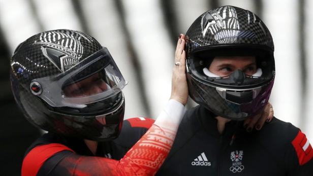 Zwei österreichische Skeleton-Athleten mit Helmen vor einem Rennen.