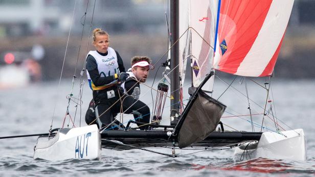 Ein österreichisches Segelteam auf einem Katamaran während eines Wettbewerbs.