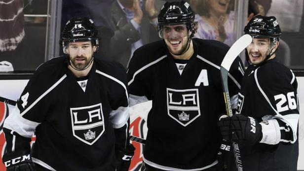 Los Angeles Kings right wing Justin Williams (L) celebrates his second goal of the game against the San Jose Sharks with teammates center Anze Kopitar (C) and defenseman Slava Voynov (R) during Game 7 of their Western Conference semi-final hockey playoff in Los Angeles, California May 28, 2013. REUTERS/Lucy Nicholson (UNITED STATES - Tags: SPORT ICE HOCKEY)