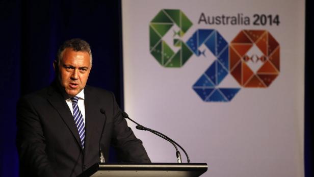 Ein Mann in Anzug spricht vor einem G20 Australia 2014 Banner.