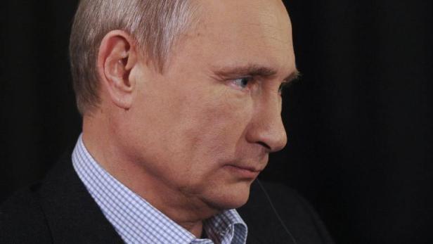 Ein Profilansicht von Wladimir Putin vor einem dunklen Hintergrund.