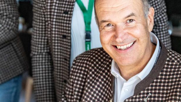 Michael Staribacher signiert ein Buch mit dem Titel „Weinviert“.