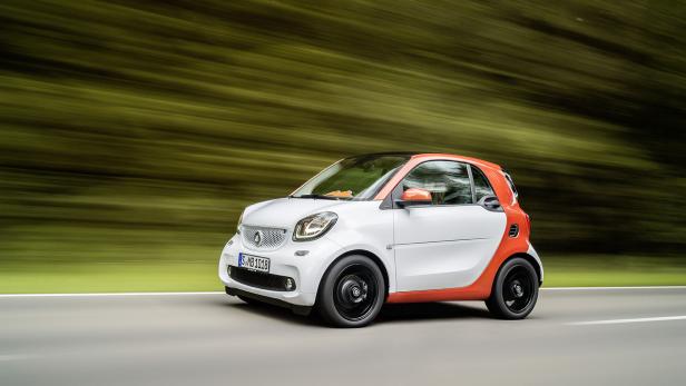 Ein weißer Smart fährt auf einer Straße.
