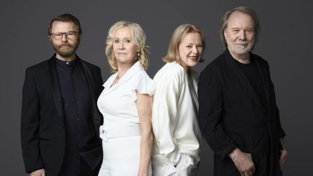 Die schwedische Popgruppe ABBA steht vor einem grauen Hintergrund.