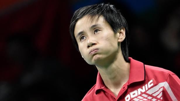 Ein Tischtennisspieler in rotem Trikot blickt nachdenklich nach oben.