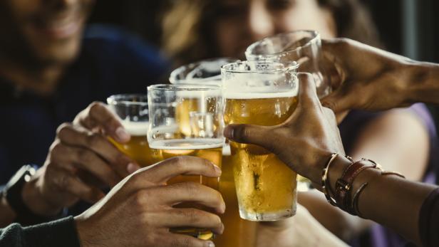 Eine Gruppe von Freunden stößt mit Biergläsern an.
