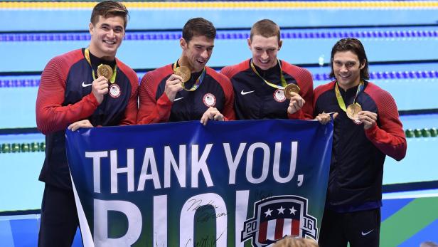 Die US-amerikanische Schwimmstaffel mit Goldmedaillen und einem „Thank You, Rio!“-Banner.