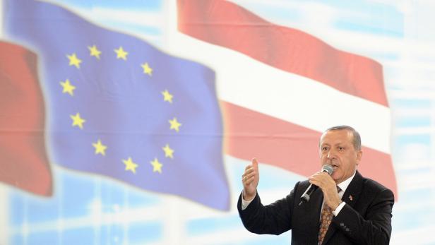 Recep Tayyip Erdoğan spricht vor den Flaggen der EU und Österreichs.