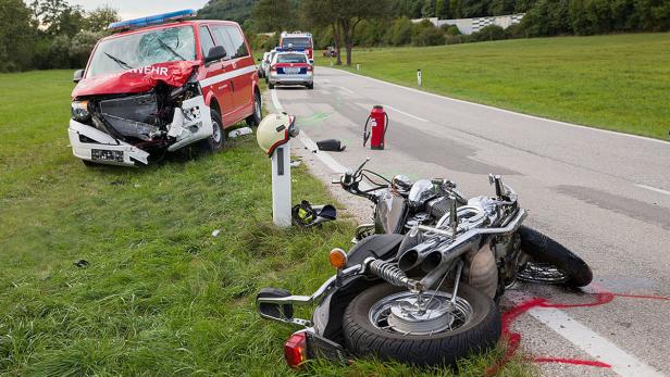 Ein Unfall mit einem Motorrad und einem Feuerwehrwagen auf einer Landstraße.